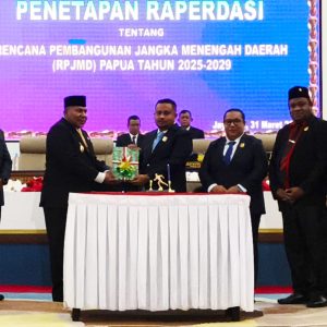Ketua DPR Papua Denny Henrry Bonai (kanan) menyerahkan dokumen Raperdasi RPJMD 2025–2029 yang baru disahkan kepada Wakil Gubernur Papua Aryoko A.F. Rumaropen (kiri) pada sidang paripurna di Jayapura, Selasa (31/3/2026)